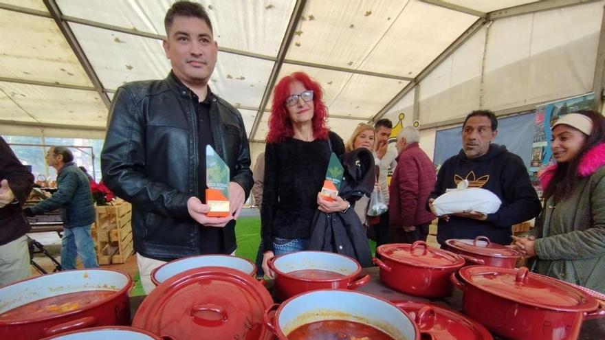 Diego Martín y Mari Luz da Costa, con sus distinciones y junto a varias potas con fabes. | M. Á. G.