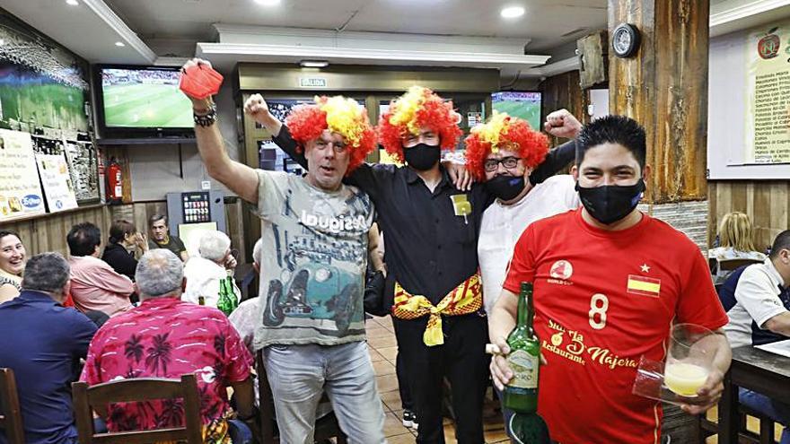 Saúl de Nájera, escanciando en Gijón con unos aficionados detrás.