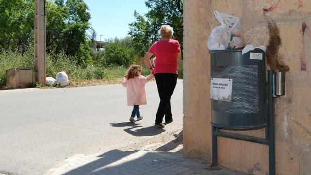 Una vecina de Binissalem pasa ante una papelera en la que se ha depÃ²sitado una bolsa de basura incorrectamente
