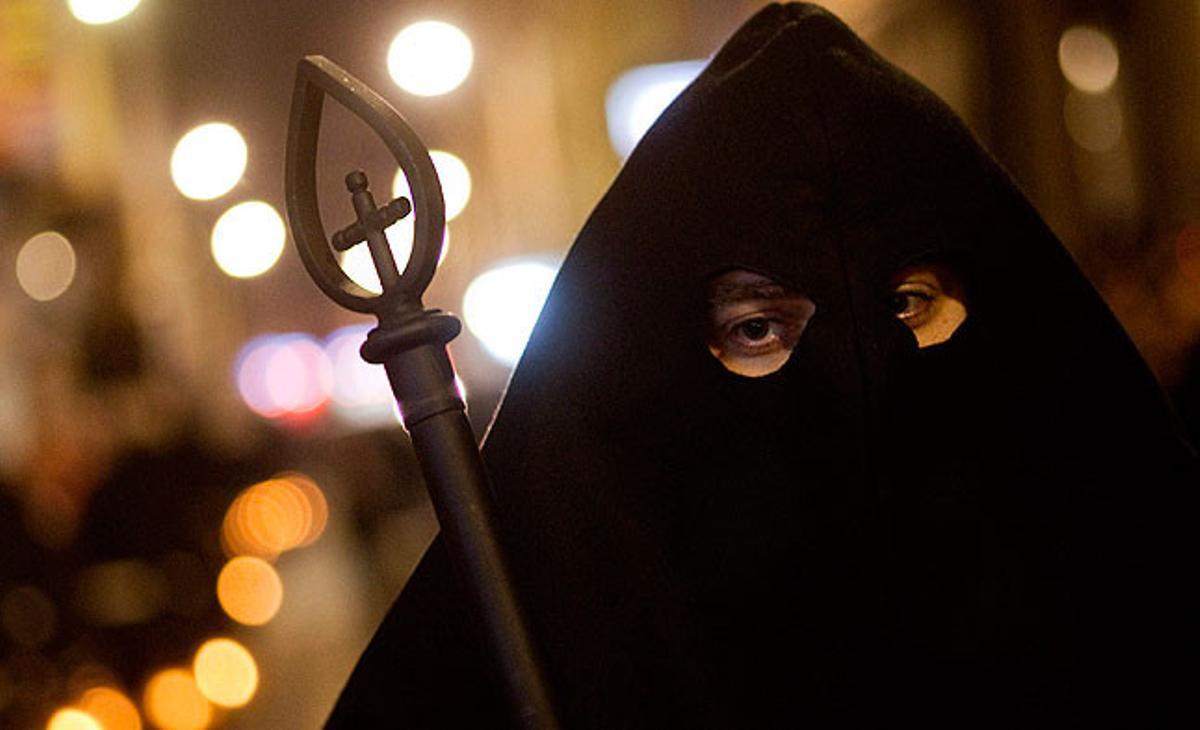 Un penitent de la germandat El Perdón participa en una processó durant la Setmana Santa, a Almeria.