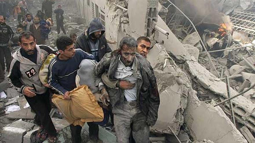 Vecinos de Gaza ayudan a un hombre herido que quedó atrapado en los escombros.