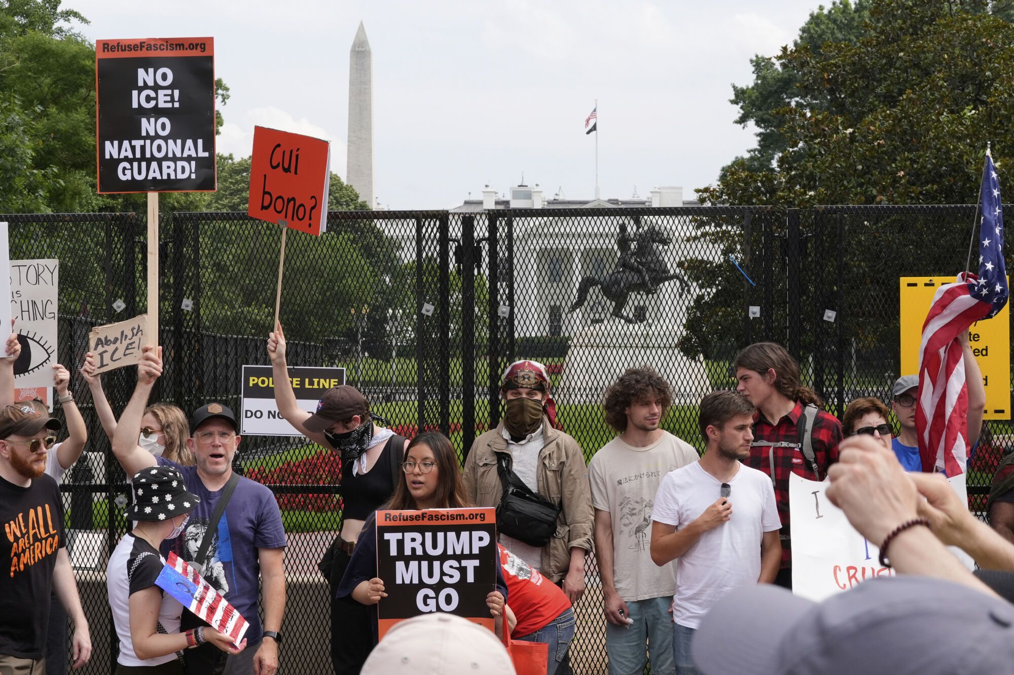 Demonstrators stand near the White House during a protest taking place on the day of a military parade commemorating the Army's 250th anniversary, coinciding with President Donald Trump's 79th birthday, Saturday, June 14, 2025, in Washington. (AP Photo/Alex Brandon)