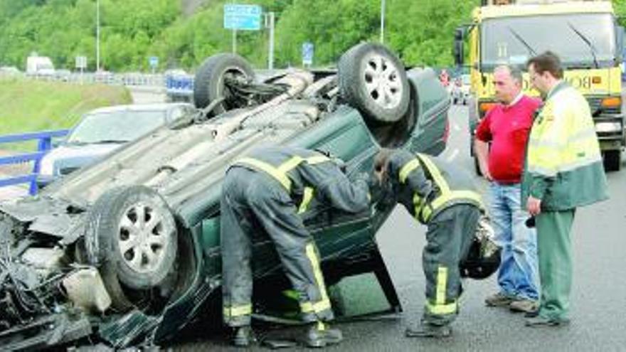 Bomberos y Guardia Civil inspeccionan el coche accidentado.