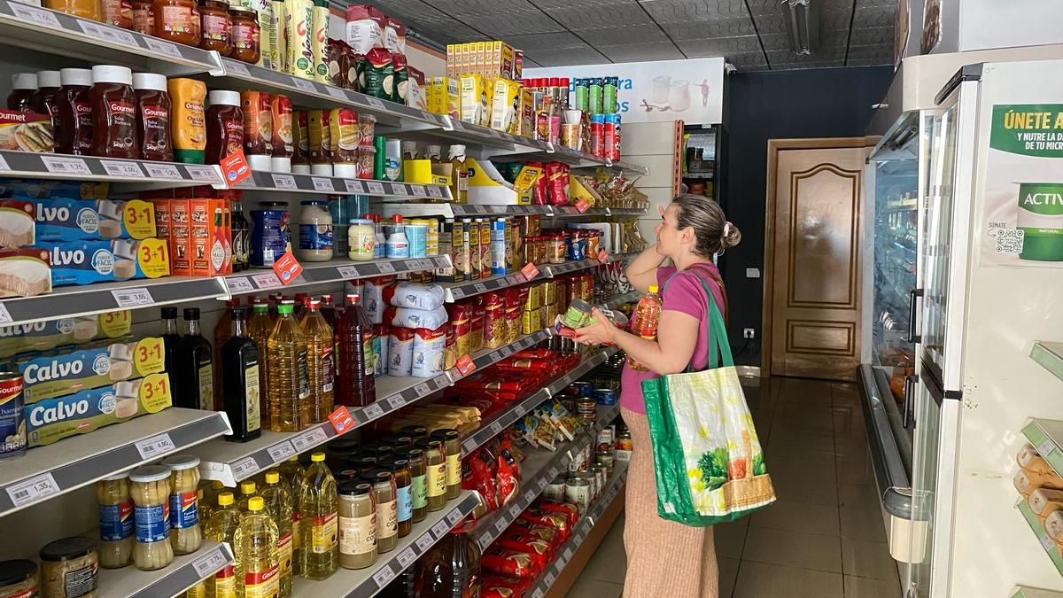 Una vecina hace acopio de alimentos no perecederos en un supermercado de València