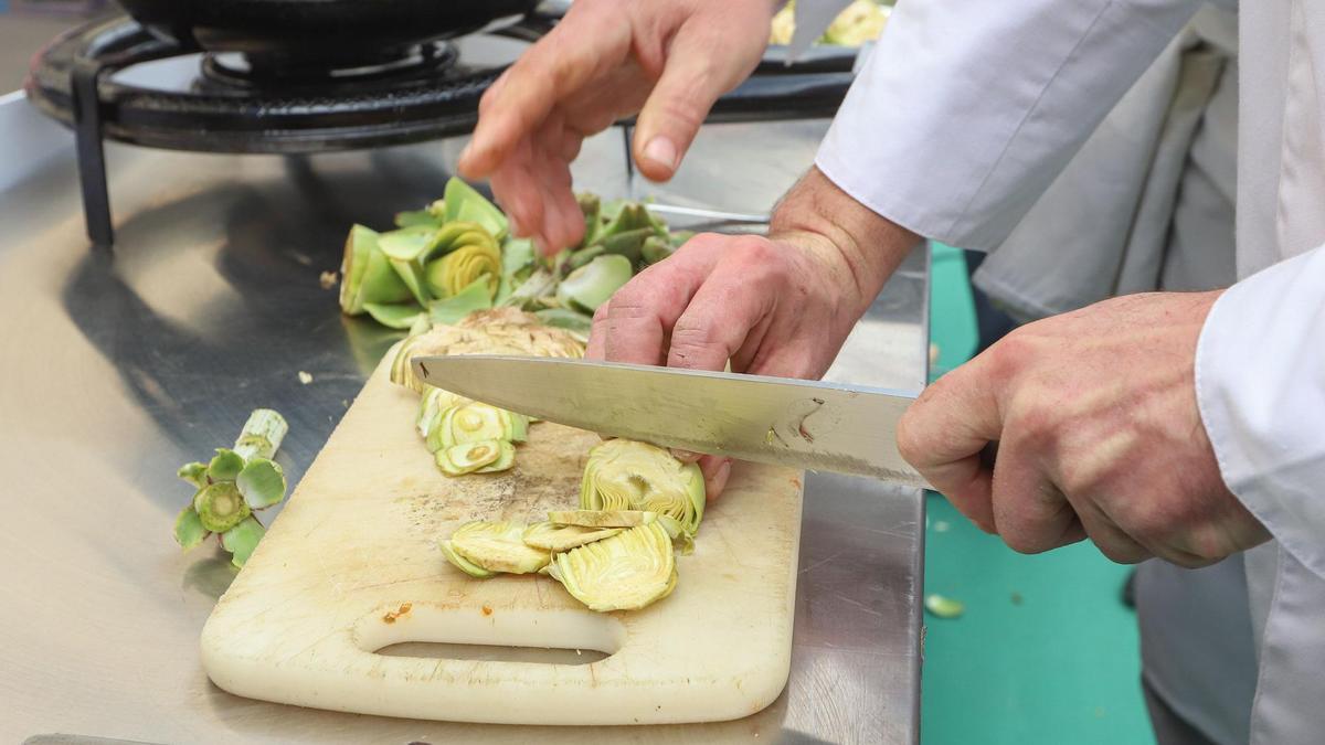 Chef cortando alcachofas frescas para una receta
