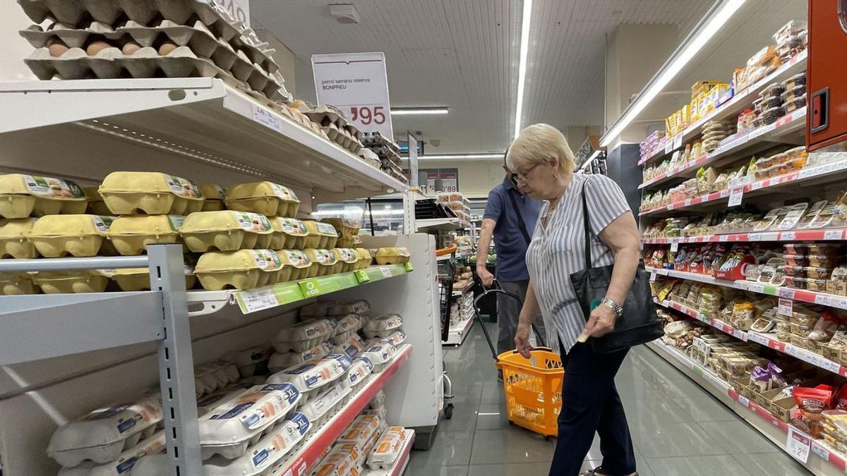 Una dona comprant ous en un supermercat. | FERRAN NADEY