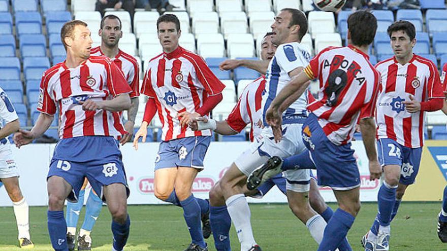 Una munió de jugadors del Girona proven de defensar una pilota a l&#039;àrea blanc-i-vermella.