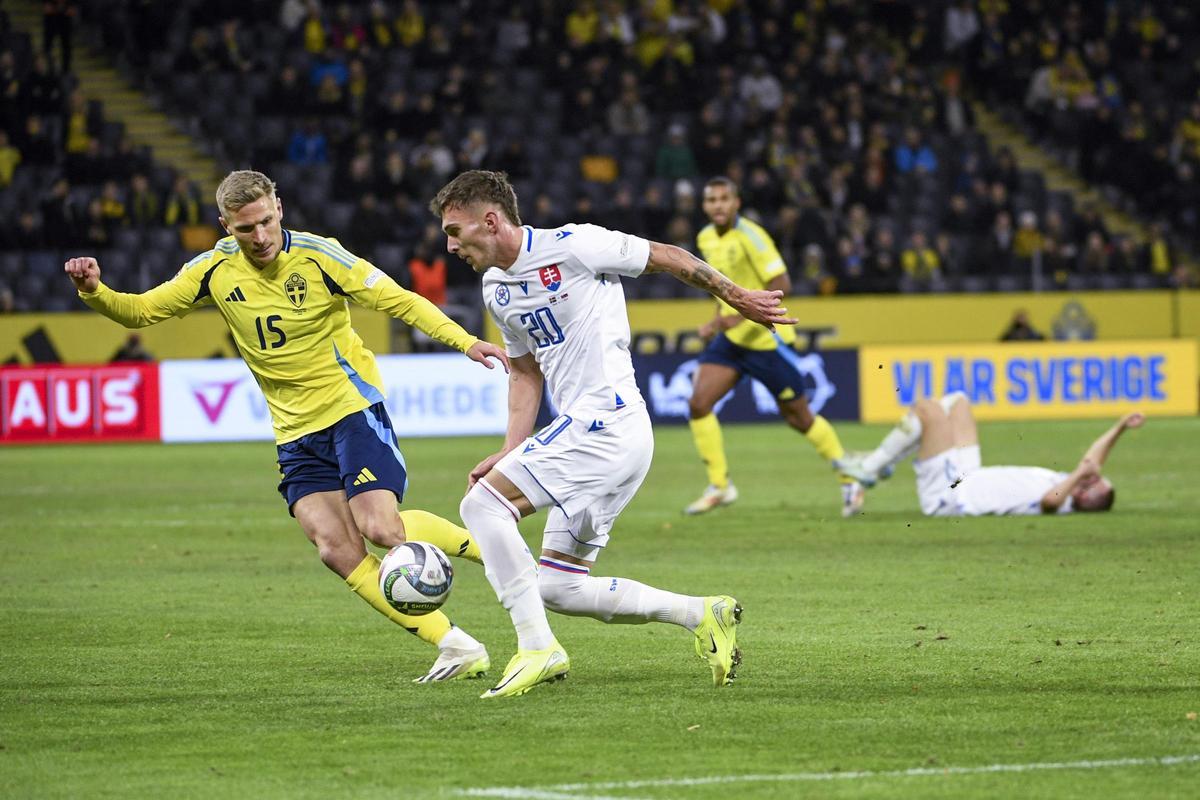 Carl Starfelt marca a un rival en un partido con la selección sueca ante Eslovaquia.
