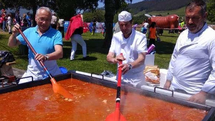 Manuel Fernández, José Manuel Araujo y Álvaro Fernández removiendo la paella.