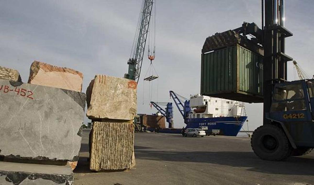Un operario traslada ayer al barco fondeado en el muelle 15 el primer bloque de mármol metido en un contenedor