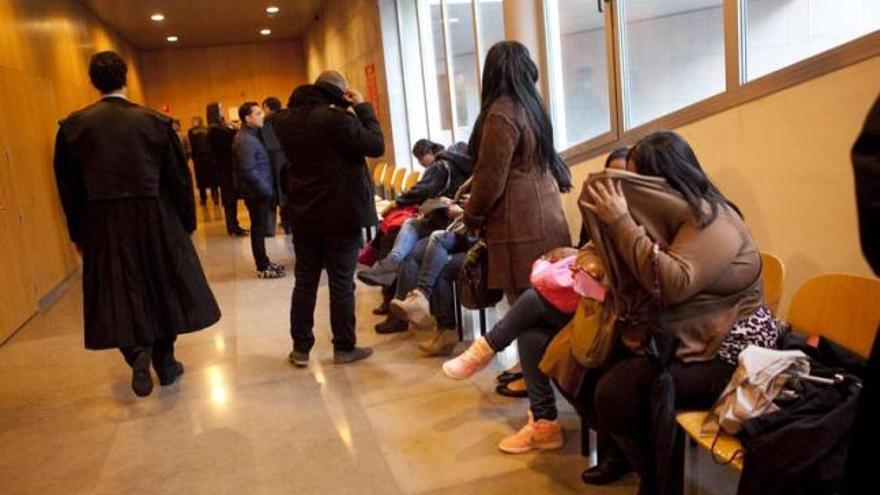 Algunos de los acusados ocultan su identidad, ayer, antes de entrar a declarar en los juzgados de Oviedo.