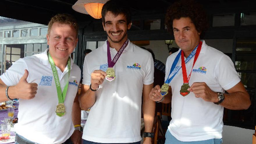 De izq. a dcha., John Beckley, Alberto Lorrio y Juan Carlos Albuixech en Costa Teguise, ayer, con las medallas de las distintas categorías de la prueba.