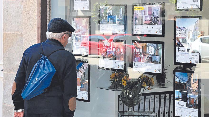 Un hombre consulta los anuncios de una inmobiliaria en Vigo.