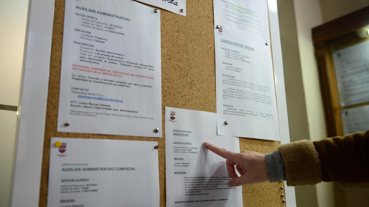 Una mujer mira las ofertas de empleo en un tablón del ayuntamiento.