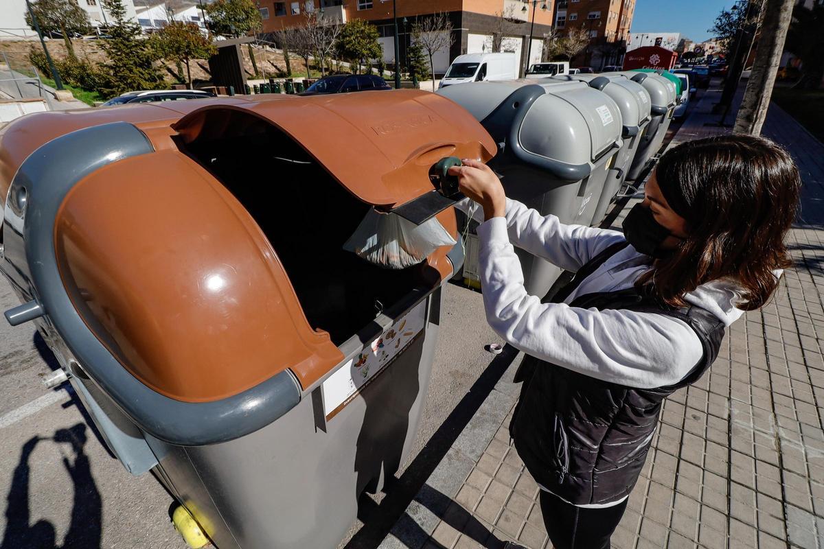 Un mujer utiliza uno de los contenedores destinados para la recogida de los restos orgánicos en Alcoy