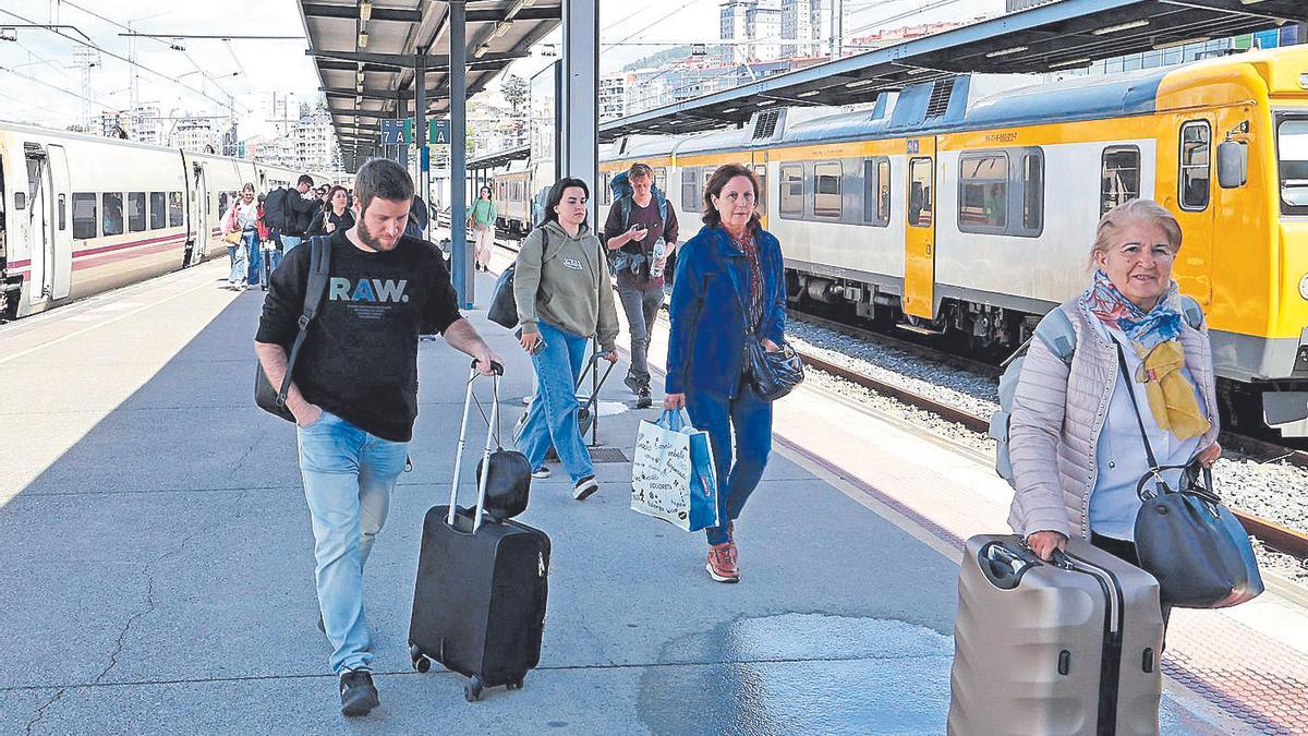 Viajeros a la bajada de un tren en la estación de Guixar, en Vigo