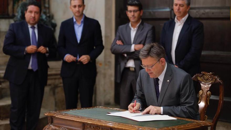 Puig firma el acuerdo en presencia de los presidentes de las tres diputaciones.