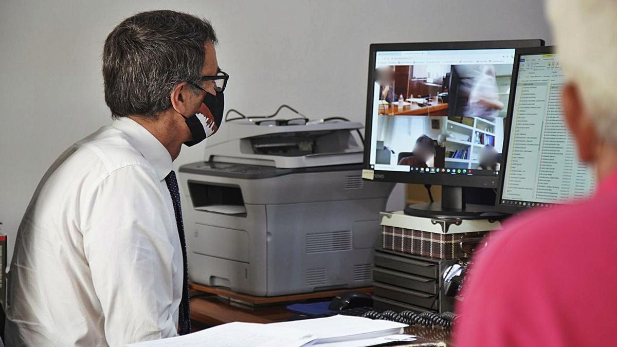 Un abogado y un testigo intervienen desde el despacho del profesional en un juicio online. | Jose Luis Fernández