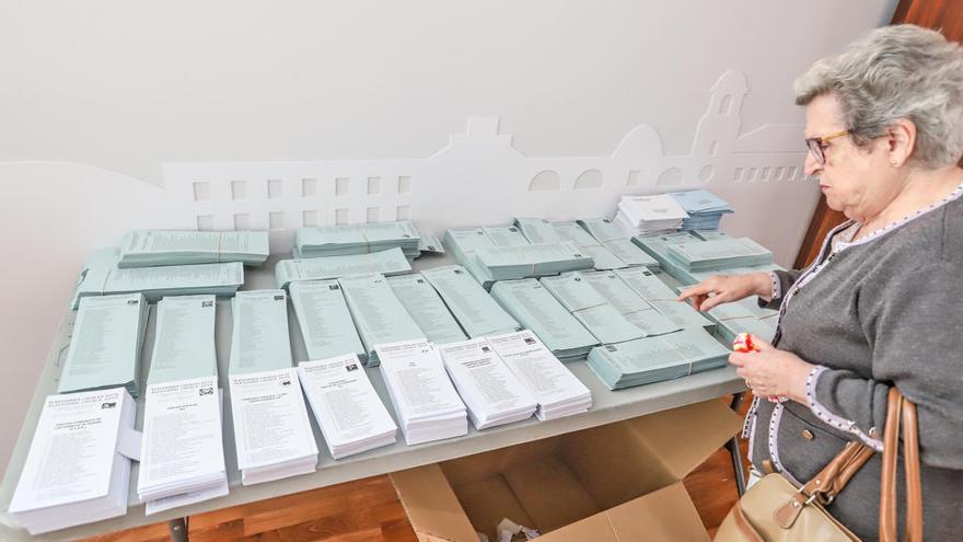 Una mesa electoral con papeletas y votantes durante las elecciones municipales y europeas celebradas el pasado domingo.