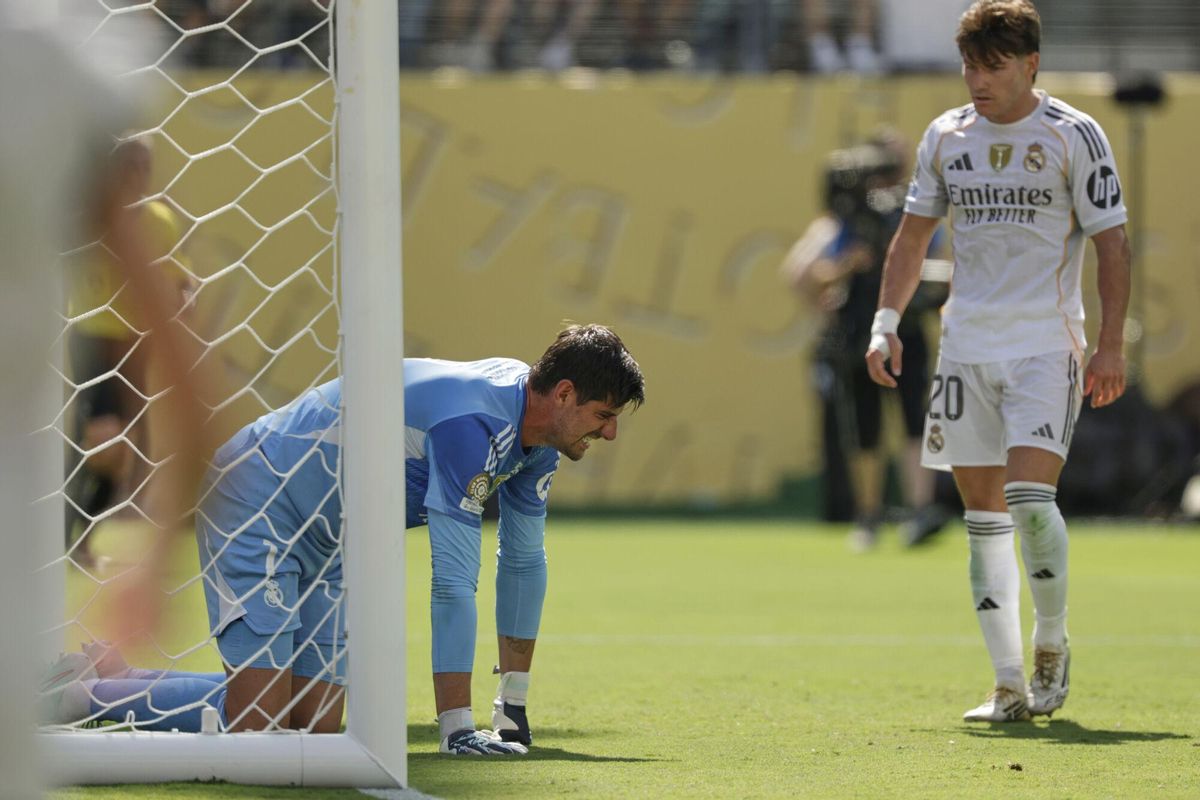 Real Madrids Thibaut Courtois kneels on the ground besides team mate Fran Garcia during the Club World Cup semifinal soccer match between PSG and Real Madrid in East Rutherford, N.J., Wednesday, July 9, 2025. (AP Photo/Adam Hunger)