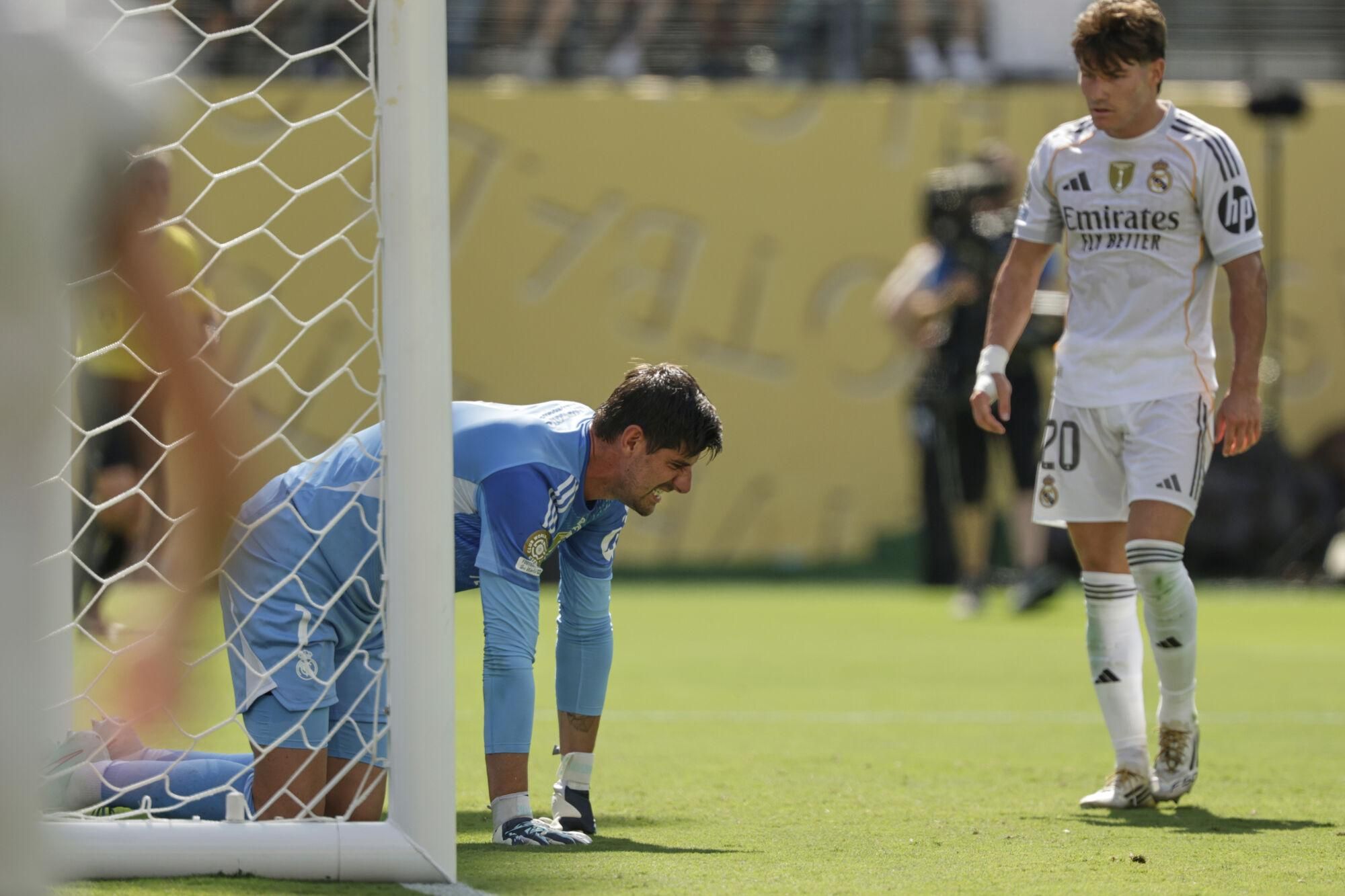 Real Madrid's Thibaut Courtois kneels on the ground besides team mate Fran Garcia during the Club World Cup semifinal soccer match between PSG and Real Madrid in East Rutherford, N.J., Wednesday, July 9, 2025. (AP Photo/Adam Hunger)