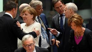 La cancillera Angela Merkel y el luxemburgués Xavier Bettel se saludan entre otros dirigentes europeos.