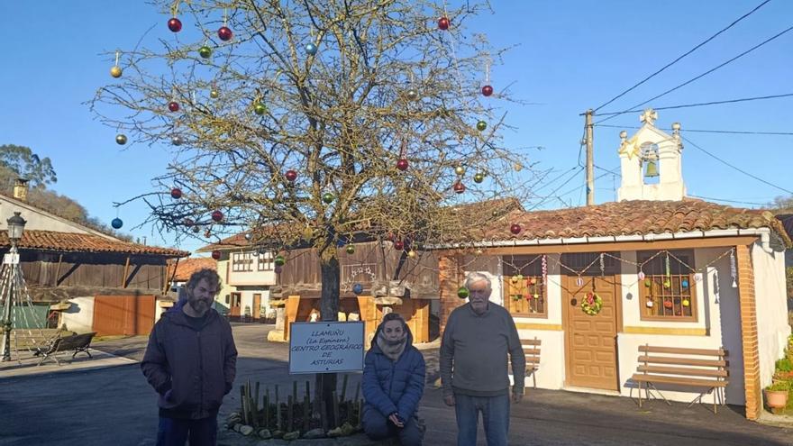 Por la izquierda, Juan Pablo y María Elvira Fernández, con Ignacio Díaz, junto al árbol que marca el centro de Asturias, decorado por Navidad. | LUCÍA RODRÍGUEZ