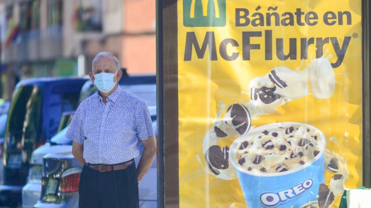 Un hombre con mascarilla parado en una calle de Cartagena.