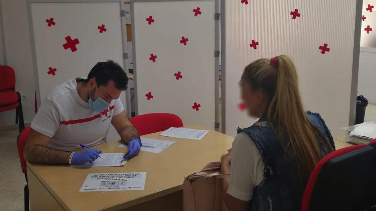 Un voluntario de Cruz Roja atendiendo a una usuaria.