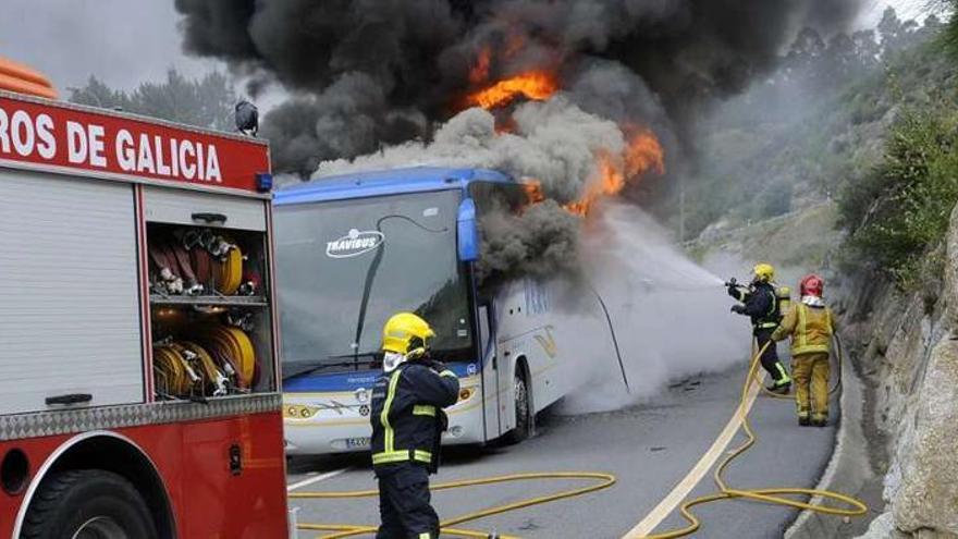 Los bomberos, en plena tarea para extinguir las llamas del autobús.