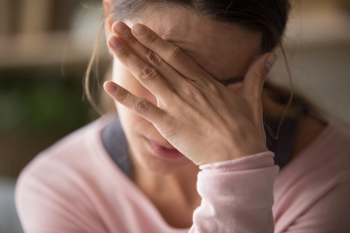 Una mujer sufre dolor de cabeza.