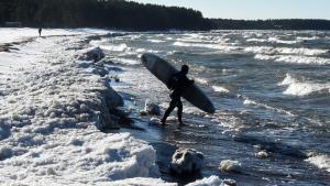 Daniil Novozhilov, de Rusia, entra en las aguas heladas del Golfo de Finlandia en el pueblo de Lipovo. La fotógrafa Olga Maltseva presenta a través de AFP un reportaje de 13 fotografías sobre el surf de invierno.