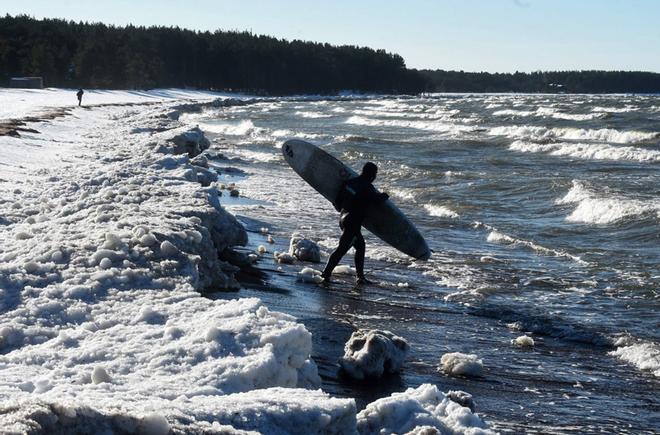 Daniil Novozhilov, de Rusia, entra en las aguas heladas del Golfo de Finlandia en el pueblo de Lipovo. La fotógrafa Olga Maltseva presenta a través de AFP un reportaje de 13 fotografías sobre el surf de invierno.