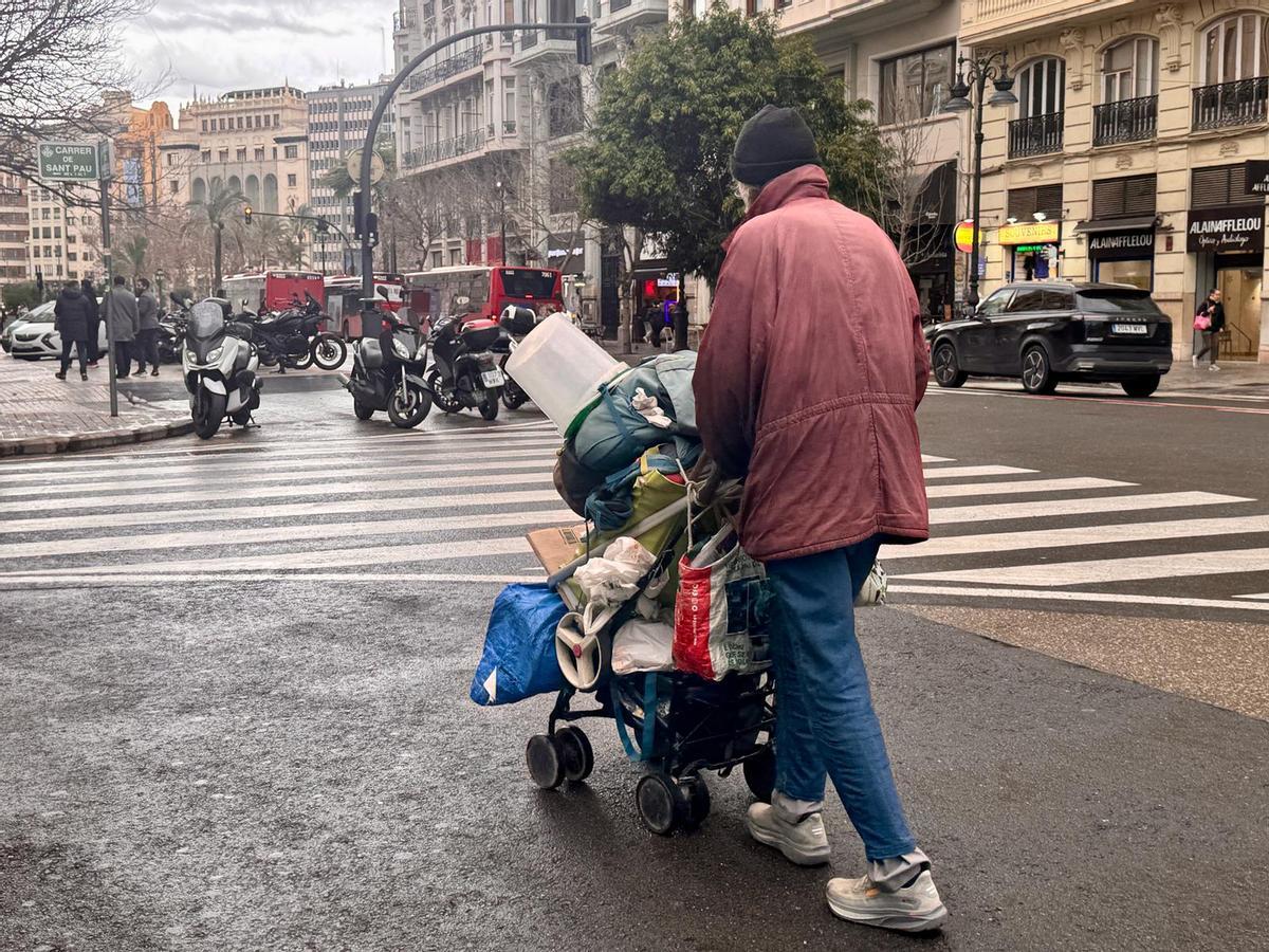 Una persona sense llar caminant per un carrer de València
