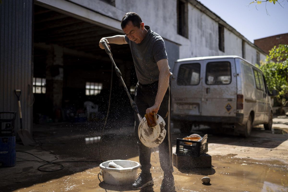 Carlos Gimeno, en Letux, quitando con agua el barro de la vajilla.