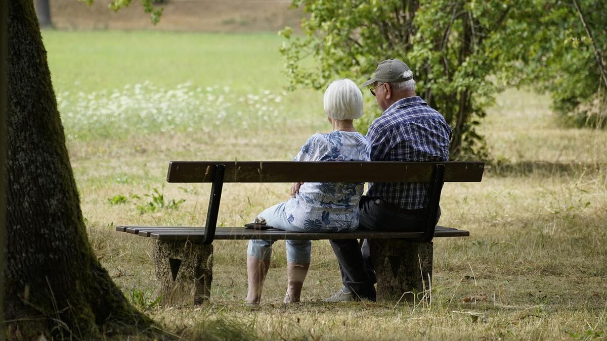 Dos personas mayores sentadas en un banco