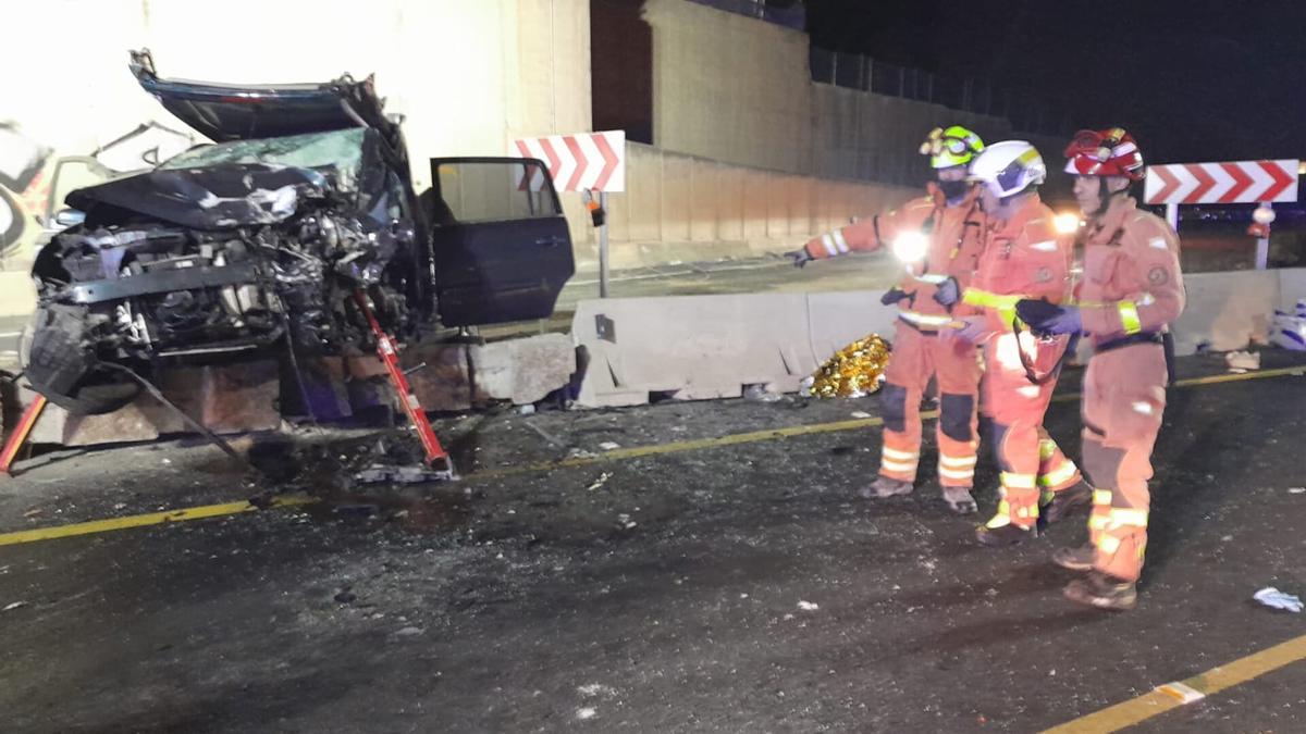 Los bomberos comprueban el estado en que ha quedado uno de los coches accidentados esta madrugada en Manises.