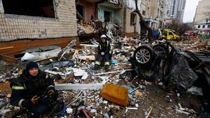 Bomberos junto a los destrozos de un edificio residencial de la ciudad de Kiev, Ucrania, tras el bombardeo ruso