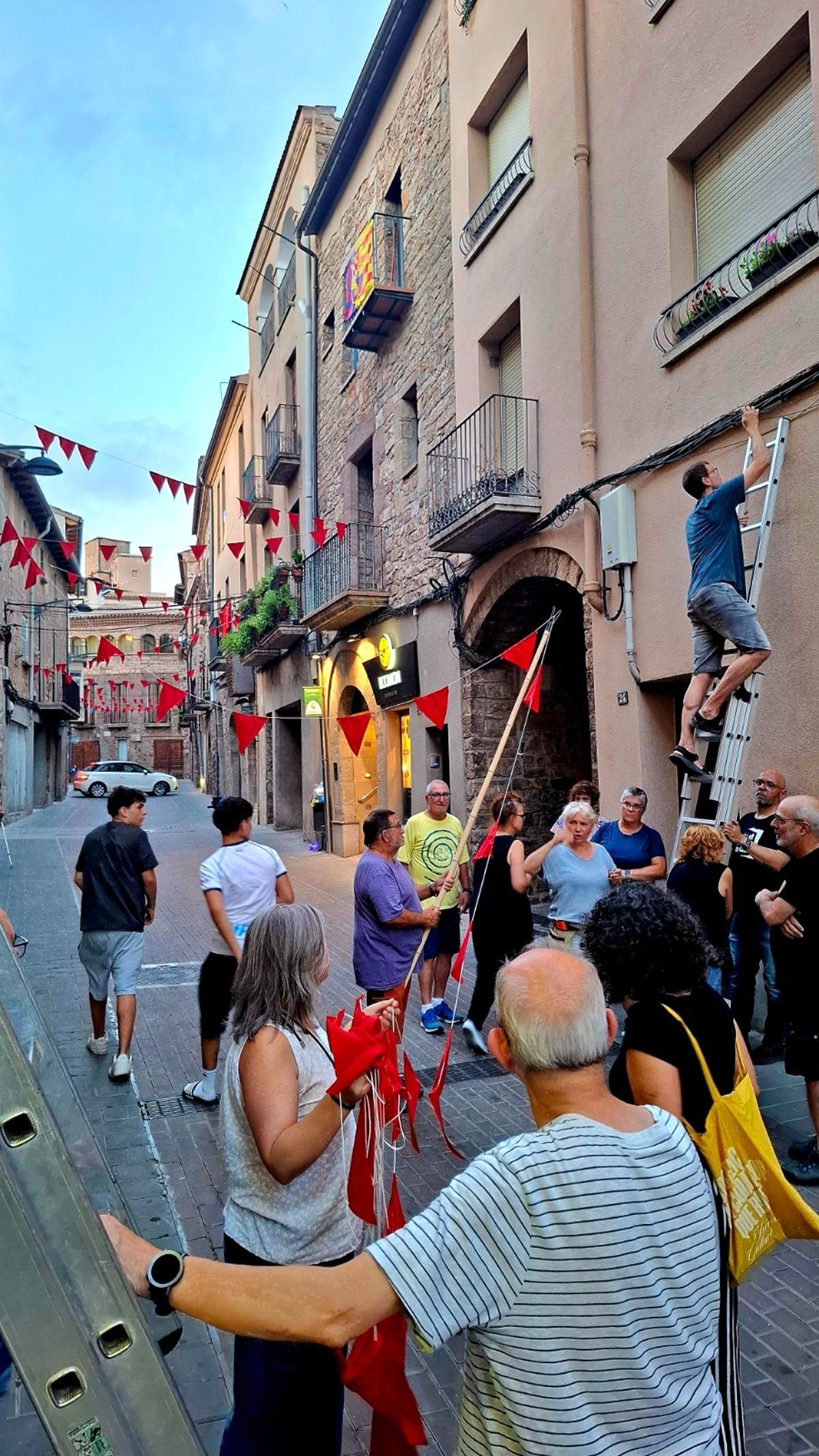 Veïns treballant en la col·locació de les banderoles