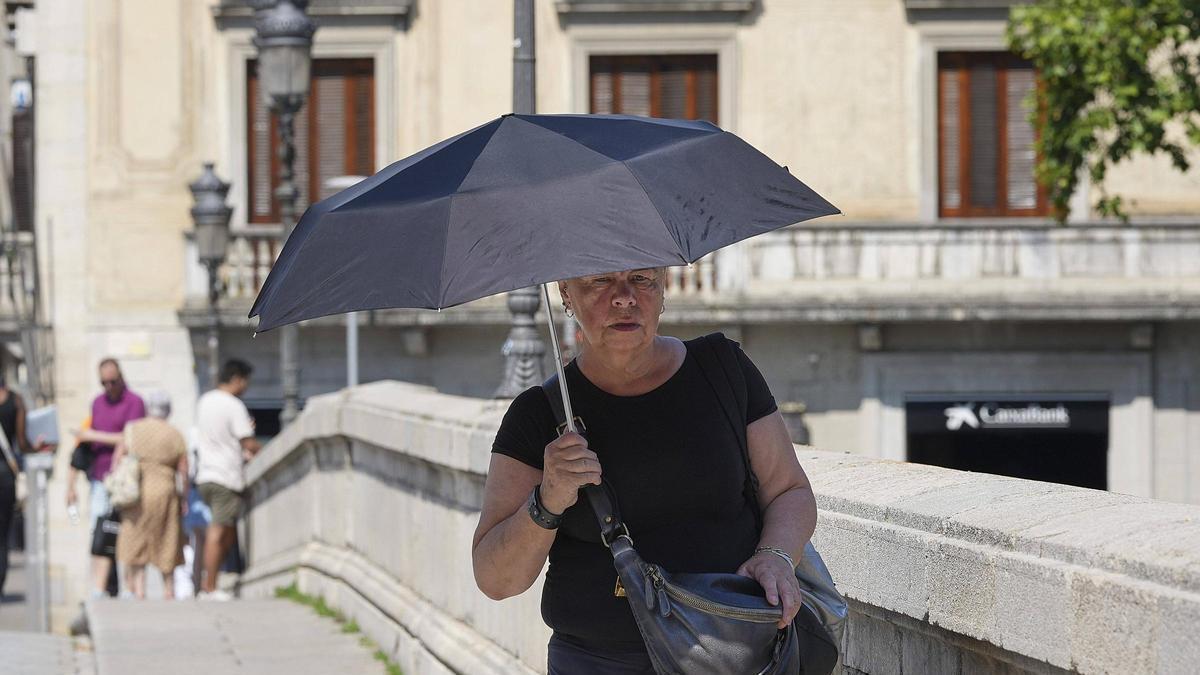 Una dona es protegeix del sol en plena onada de calor a Girona