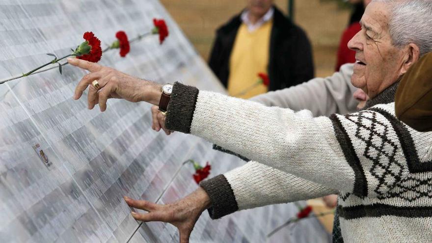 Familiares de los asesinados depositaron claveles rojos junto a las placas de mármol con el nombre de las víctimas.