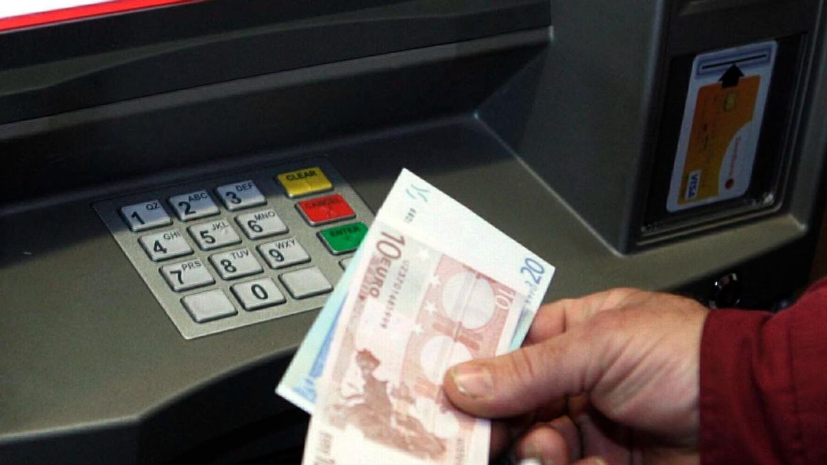 Un hombre saca dinero de un cajero automático. Un hombre saca dinero de un cajero automático.