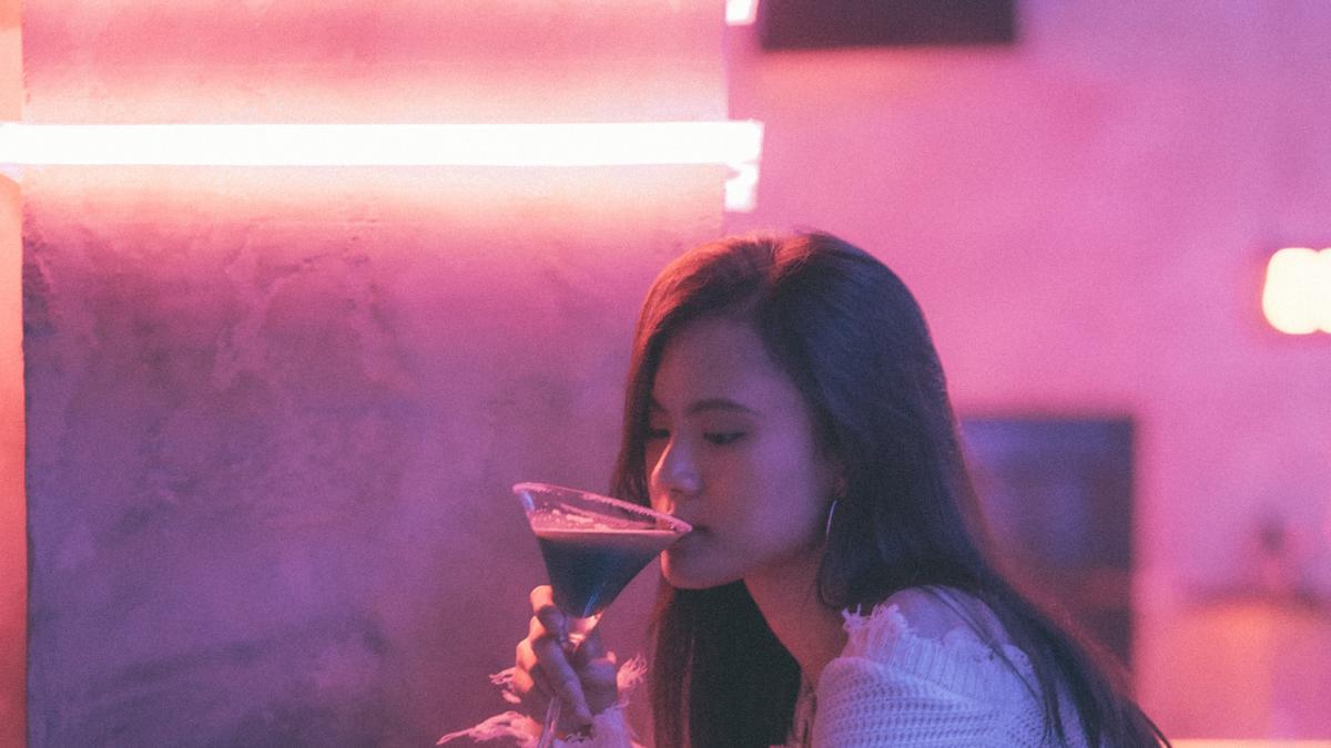 Chica tomando una copa en el bar