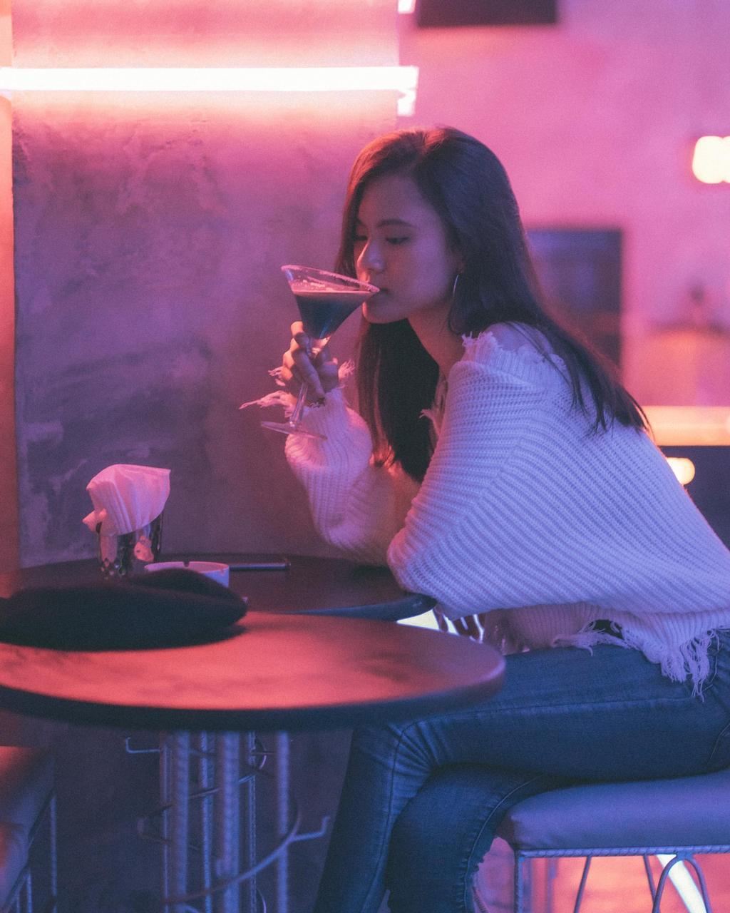 Chica tomando una copa en el bar