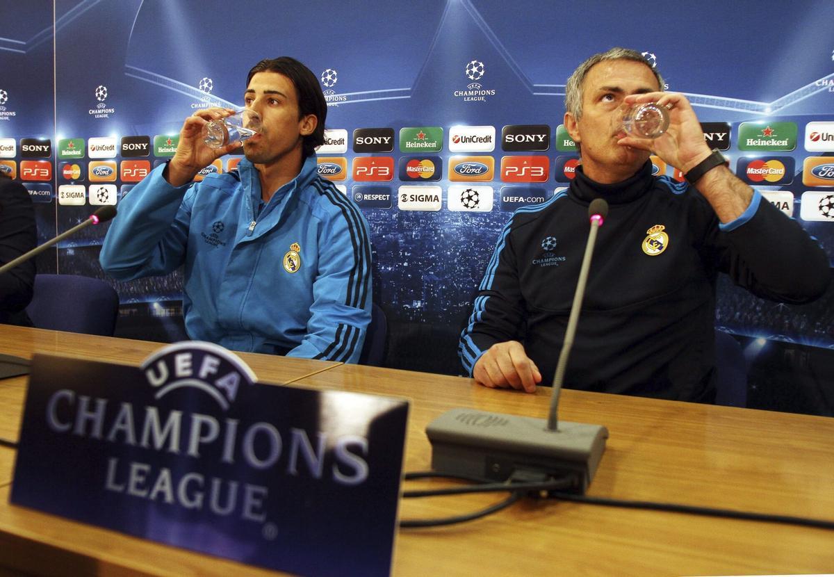 El centrocampista alemán Sami Khedira bebe agua junto a José Mourinho durante una rueda de prensa en Nicosia antes de un partido de Champions del Real Madrid