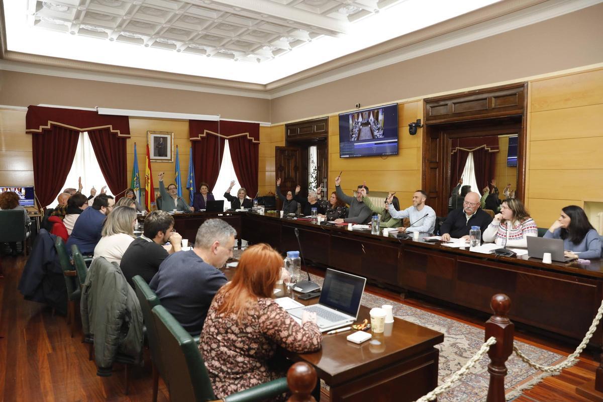 Pleno de aprobación de los presupuestos municipales de Langreo para 2026 con los concejales de IU y PSOE, con la mano levantada, votando a favor de las cuentas