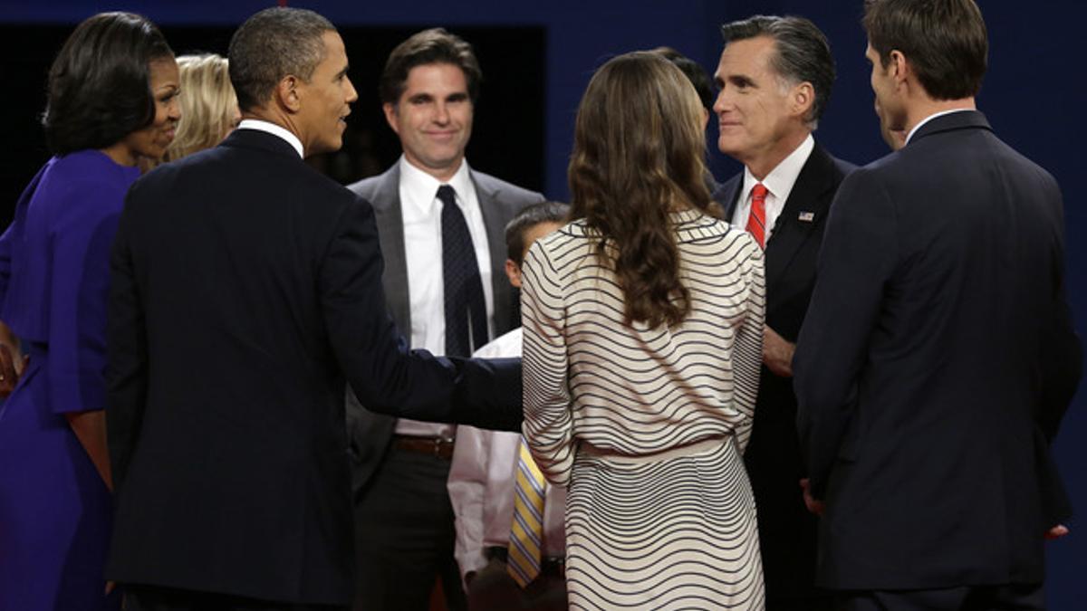 Obama y Romney, rodeados por sus familias, antes del debate, anoche en Denver.