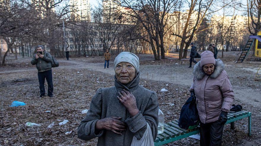 Residentes del edificio residencial que fue alcanzado por los bombardeos de artillería se lamentan, en Kiev.