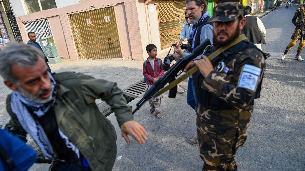 Un miembro de los talibanes empuja a un periodista que cubre una manifestación de mujeres frente a una escuela en Kabul.