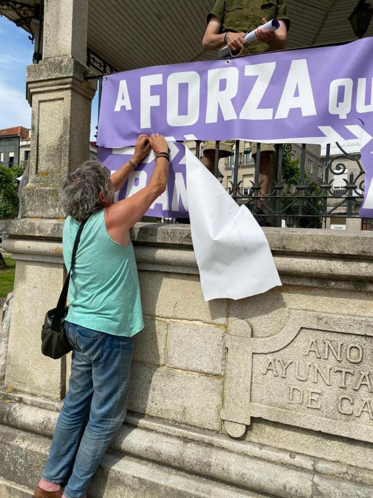 Miembro de Podemos cosiendo su pancarta en el palco de la música.